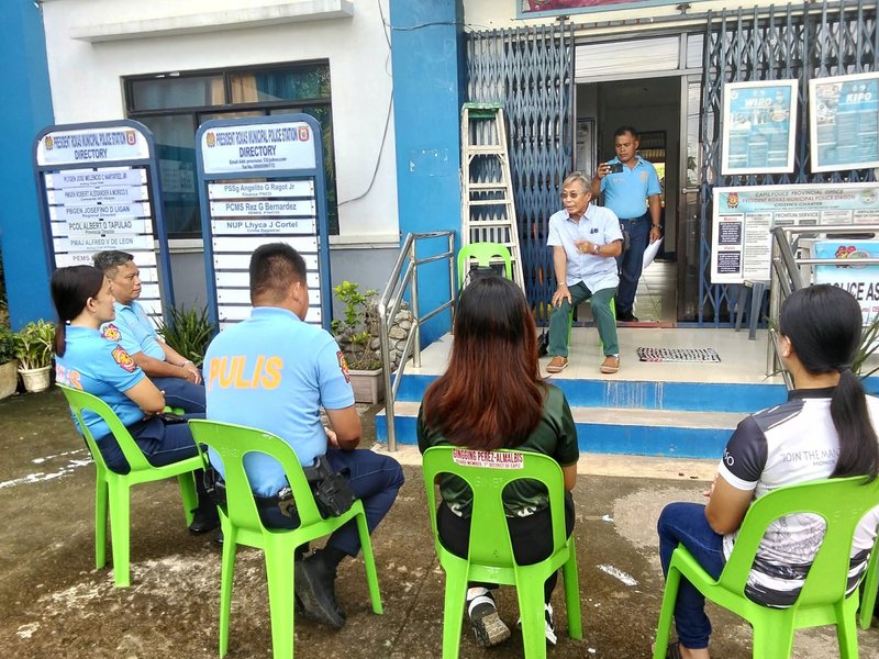Pastor Ric speaking with police officers and community members outside a municipal police station
