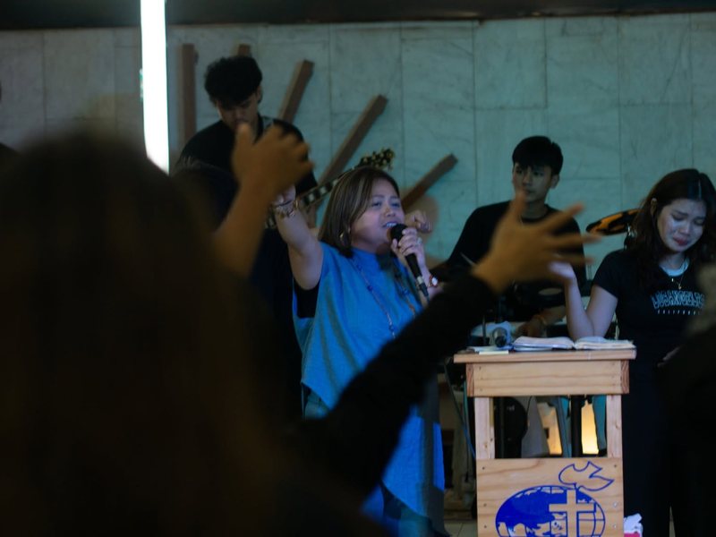 Pastor Hazel leading worship with the band